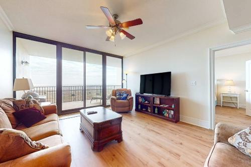 a living room with a ceiling fan and a television at Holiday Isle 413 in Dauphin Island