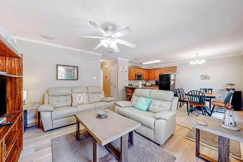 a living room with a couch and a table at Perfectly located condo with beach access - deck internet W&D & AC in Dauphin Island