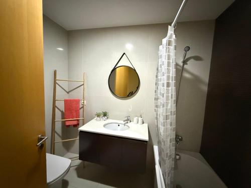 a bathroom with a sink and a mirror at Sol Poente Praia Apartment in Apúlia