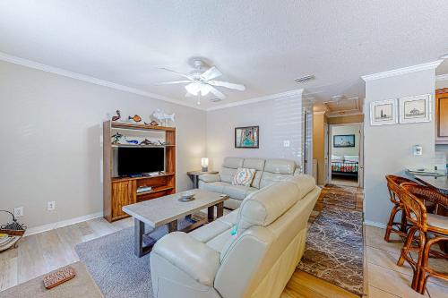a living room with a couch and a tv at Perfectly located condo with beach access - deck internet W&D & AC in Dauphin Island