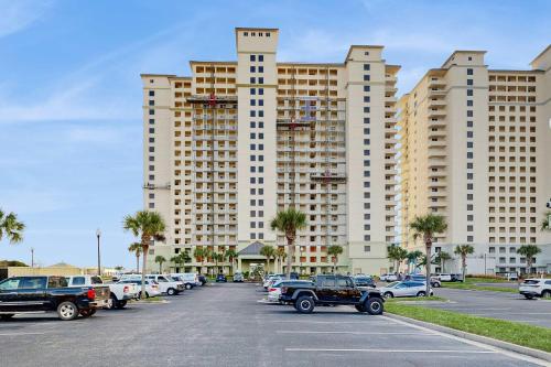 a parking lot in front of a large building at Spacious beachfront condo with full kitchen shared pool and beach access in Gulf Shores