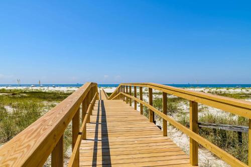 a wooden boardwalk leading to the beach at Gulf-Front Condo with Balcony Shared Pools and Beach Access in Dauphin Island