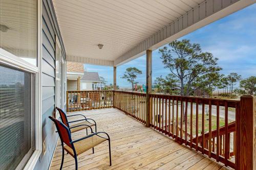 a porch with two chairs and a balcony with a view at Gulfview duplex with panoramic views large balcony and internet in Dauphin Island