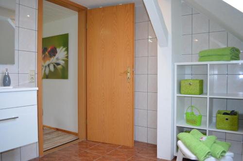 bagno con asciugamani verdi e porta in legno di Ferienwohnung Gänseblümchen a Bad Wilsnack