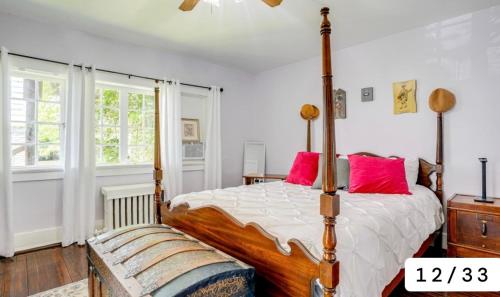 a bedroom with a wooden bed with red pillows at Swimming Under The Stars In The Historical District in Lynchburg