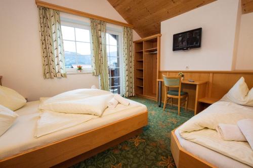 a hotel room with two beds and a desk at Appartement Jagdhof in Flachau