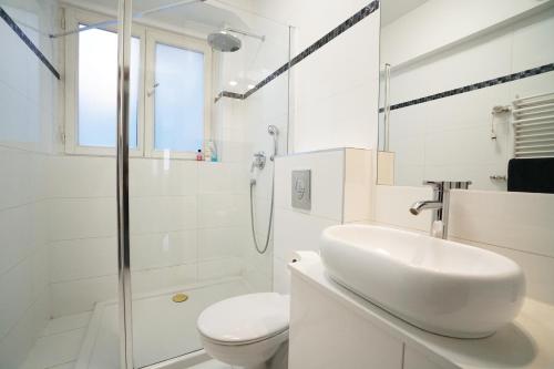 a white bathroom with a sink and a toilet at Kiełbaśnicza 1a RYNEK 3 pok osobne 65 m2 in Wrocław