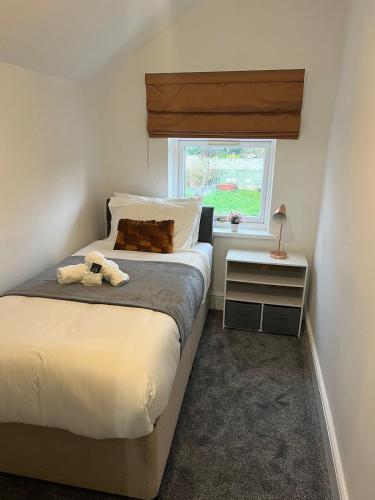 a bedroom with a bed with a teddy bear on it at Anglesey House in Burton upon Trent