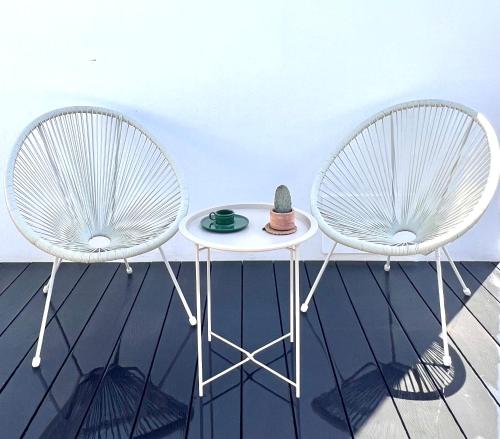 two chairs and a table with a hat on it at Habitación de invitados Casa Lume in Tahiche
