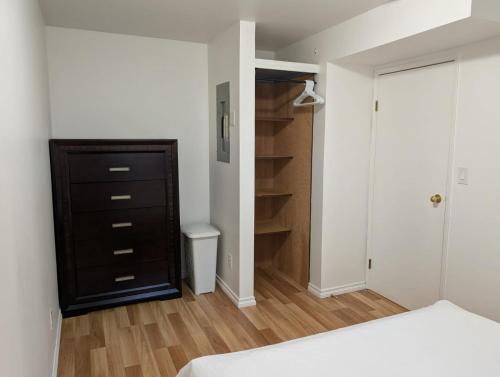 a bedroom with a bed and a dresser and a closet at Ashwood monthly in Courtenay