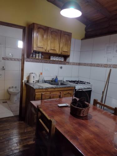 a kitchen with a wooden table and a stove at Cabañas y Bungalow " La Comarca" in Concepción del Uruguay