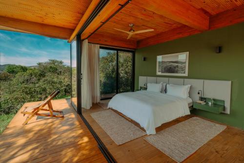 a bedroom with a bed and a large window at Ibiti Village in Lima Duarte