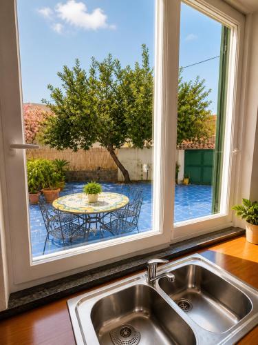 a kitchen sink with a window overlooking a patio at Domus Pannella - Endless Summer in Lacco Ameno