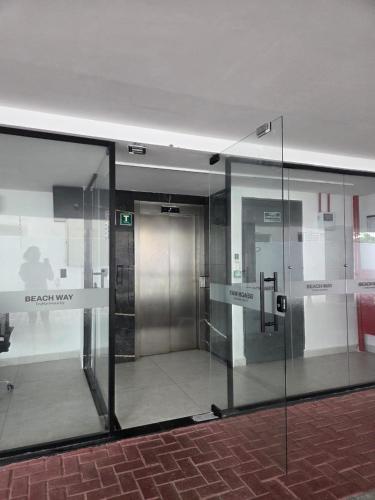 an elevator in a building with a glass wall at Flat Só Alegria in Cabedelo
