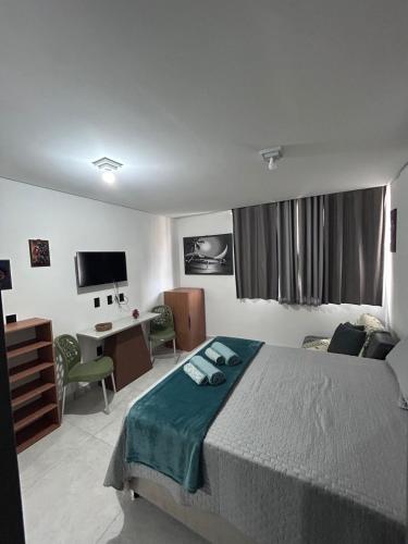 a bedroom with a bed and a desk with a computer at Flat Só Alegria in Cabedelo