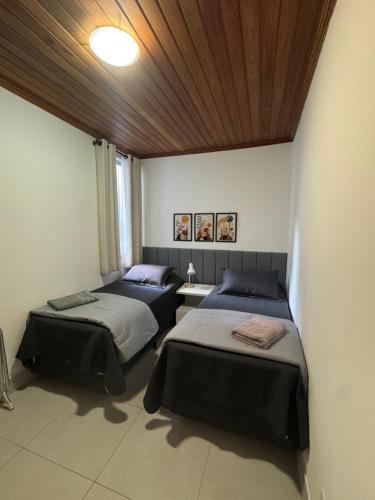 a room with two beds and a wooden ceiling at Casa da Glória 2 in Diamantina