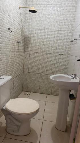 a bathroom with a toilet and a sink at Casa Mobiliada 4 camas e 2 quartos in Juazeiro do Norte