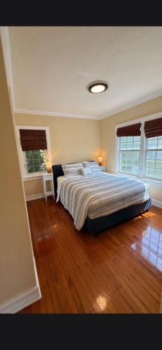 a bedroom with a large bed and wooden floors at Casa de David from the 1920s Era in West Palm Beach