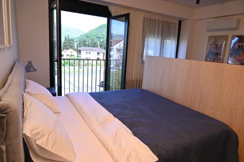 a bedroom with a bed with a large window at Apartment 84 in Donja Lastva