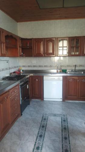 a kitchen with wooden cabinets and white appliances at Hotel casa inglesa in Buga