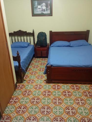 a bedroom with two beds and a patterned floor at Hotel casa inglesa in Buga