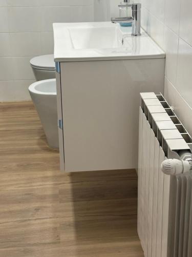 a white bathroom with a sink and a toilet at Camera vicino Ospedale Maggiore, Concerti e Aeroporto Bologna 60 mq in Bologna