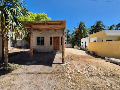 ein kleines Haus mit einer Holzveranda neben einem Gebäude in der Unterkunft Casa Haema in El Cuyo