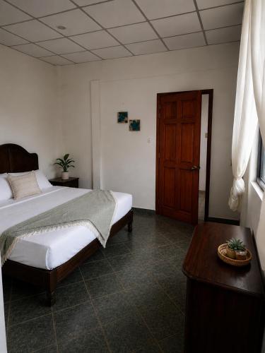 a bedroom with a bed and a wooden door at Casa Cultivo in Brisas de Zicatela