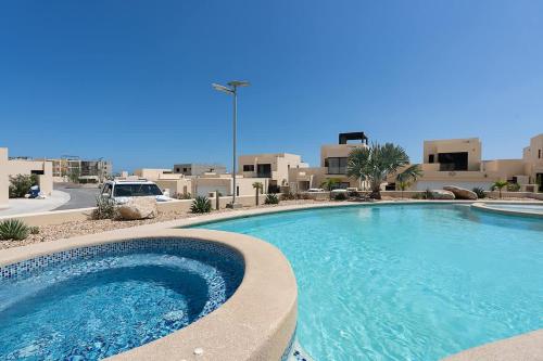 a large swimming pool in front of a building at Modern 2BR Condo Close to Downtown Cabo in Cabo San Lucas