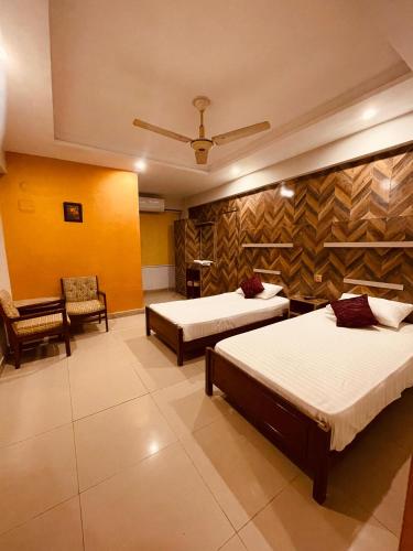 a hotel room with two beds and a chair at Solo Hotel in Sargodha