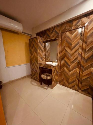 a bathroom with a vanity with a mirror and a stool at Solo Hotel in Sargodha