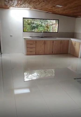 a white kitchen with a sink and a tv on the wall at Cumbre Serena by Montea in Empalme