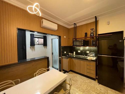 a kitchen with a white table and a refrigerator at Studio aconchegante - Próx Thermas - Carrara de Carrara in Andradina