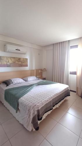 a bedroom with a large bed and a window at Kariri Beach Waterfront Retreat in Caucaia