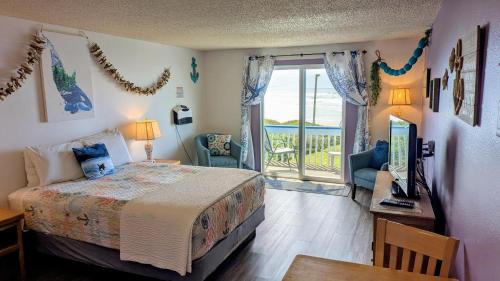 a bedroom with a bed and a view of the ocean at Silver Surf Motel in Yachats
