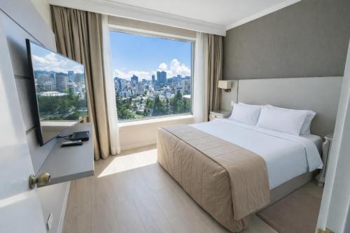 a hotel room with a bed and a large window at Torres de Suites by InAmazonas in Quito