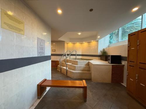 a bathroom with a tub and a table and a bench at Torres de Suites by InAmazonas in Quito