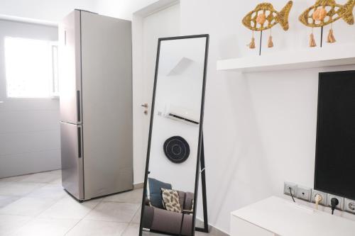 a mirror in a white room with a refrigerator at Antel apartment in Naousa