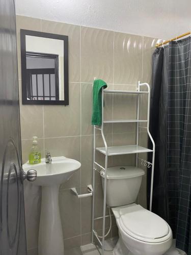 a bathroom with a toilet and a sink and a mirror at Casa Armonia in Honda
