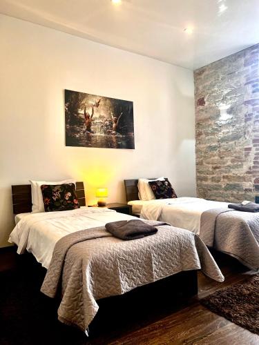 ein Schlafzimmer mit zwei Betten und einem Gemälde an der Wand in der Unterkunft Vabriku 6 Apartment with sauna in Rakvere