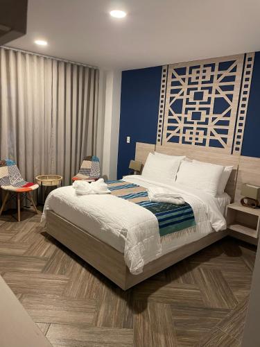 a bedroom with a large bed with a blue wall at Nativo Hotel in Popayan