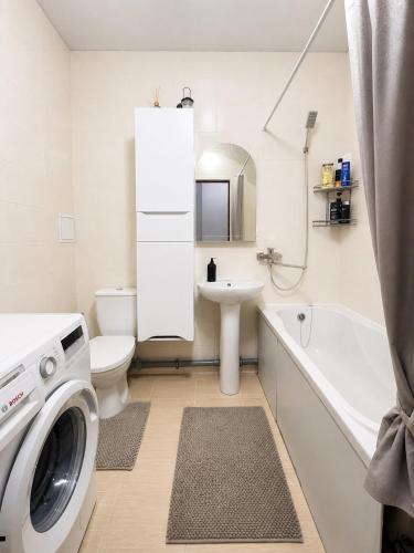 a white bathroom with a washing machine in it at 7 Apartmens ЖК 7-Небо Аквапарк Промринок 7 in Odesa