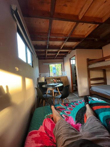a person laying on a bed in a room at Hospedaje Maika Rapa Nui in Hanga Roa