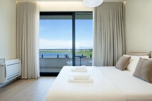 a bedroom with a large white bed and a large window at Villa Cosmo Panorama in Rrashbull