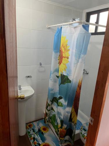 a bathroom with a shower with a sunflower shower curtain at Hospedaje Maika Rapa Nui in Hanga Roa