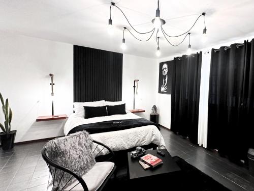 a black and white bedroom with a bed and a table at Hotel Homsty in San Martín Texmelucan de Labastida