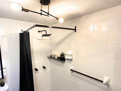 a bathroom with a shower with a black shower curtain at Hotel Homsty in San Martín Texmelucan de Labastida