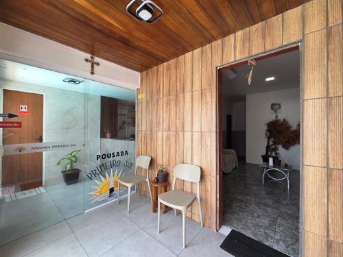a room with two chairs and a table and a glass door at Pousada Primeiro Sol in João Pessoa