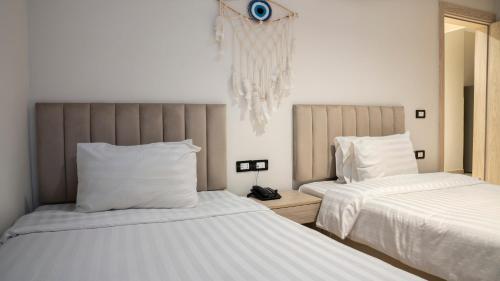 a bedroom with two beds with white sheets at TK Royal Hotel & SPA in Hurghada