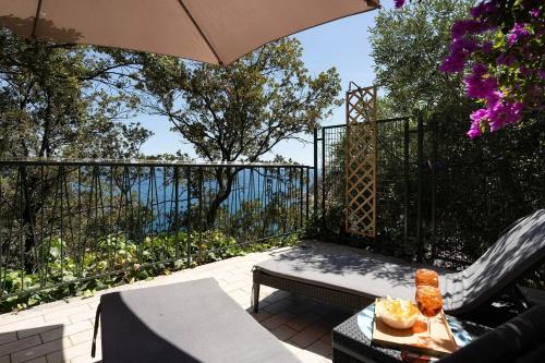 a patio with an umbrella and a bench and a table at Blue & Green Apartments in Erchie